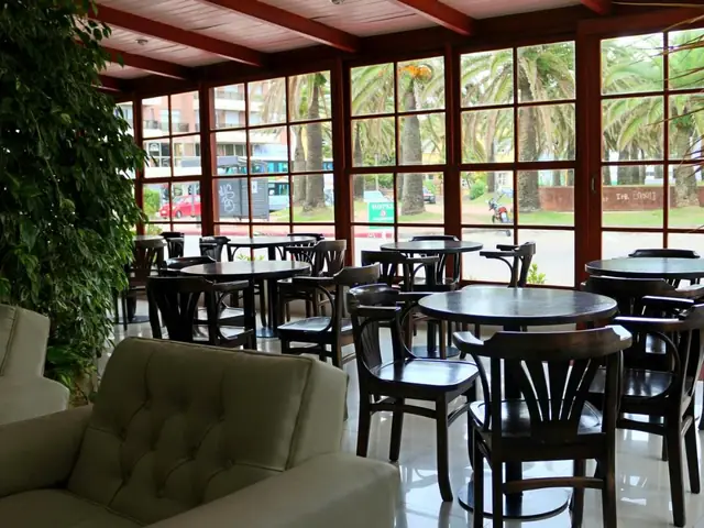 Cafetería vidriada del Hotel San Martin, con mesas frente a la plaza